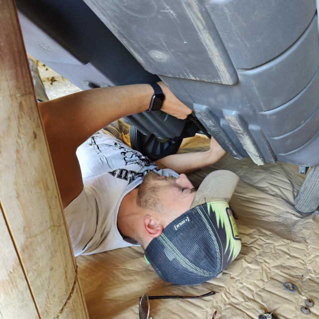 Emmanuel en train de placer le tendeur de chaine, jamais utilisé.